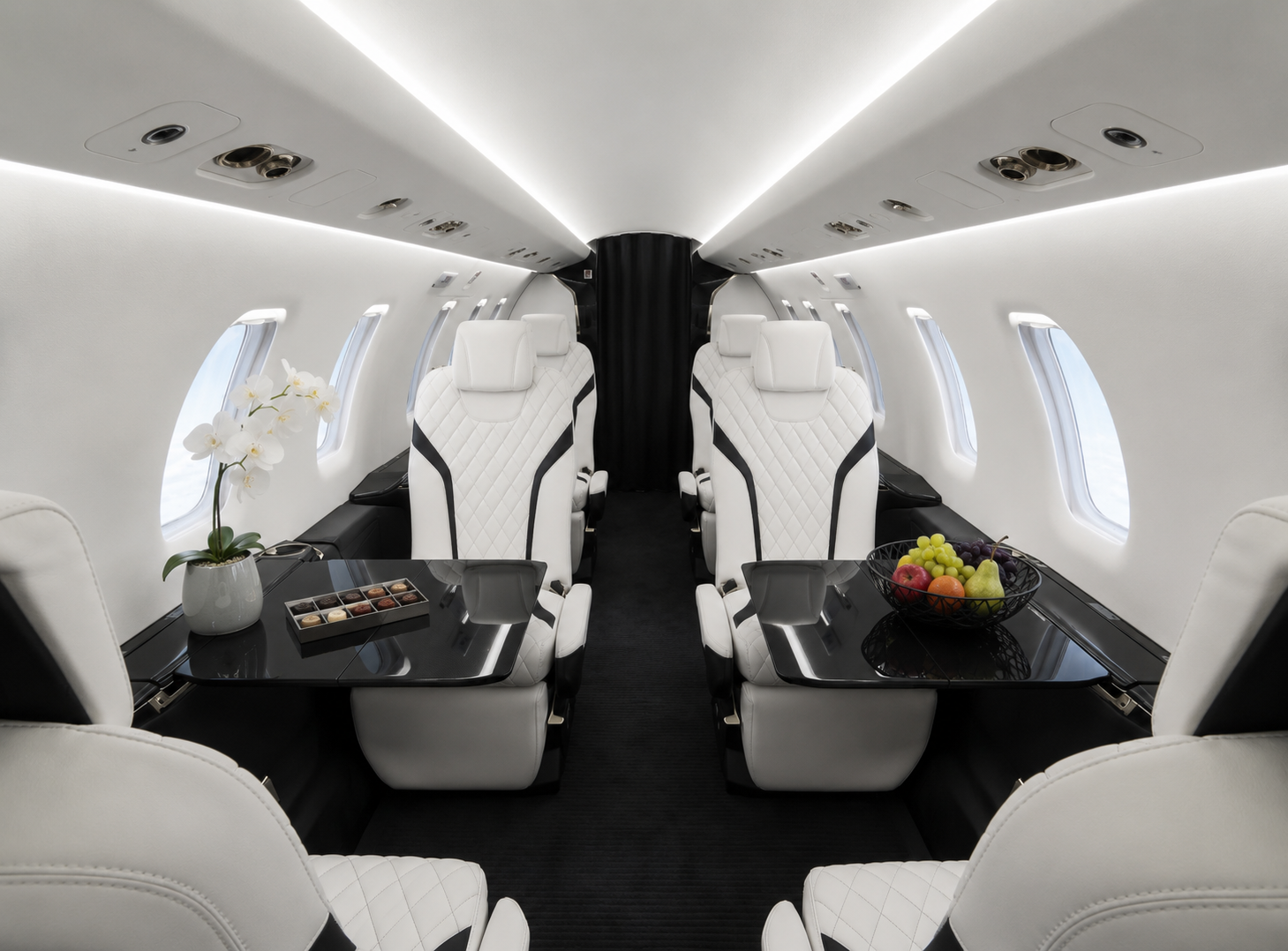 Luxury cabin of a Pilatus PC-24 private jet with white leather seats, a spacious aisle and a modern black-and-white interior.